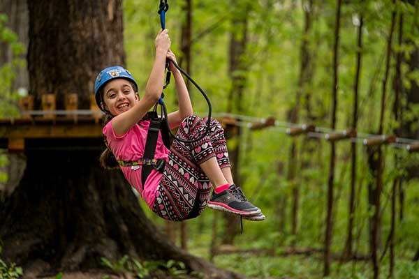 ToDoOntario - Treetop Trekking, girl smiling zipline